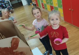 dziewczynki malują domek z piernika